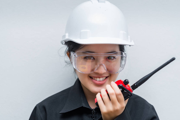 Angry Asian engineer woman wearing glasses,using radio communication on white background,thailand technician use walkie talkie for work - Φωτογραφία, εικόνα