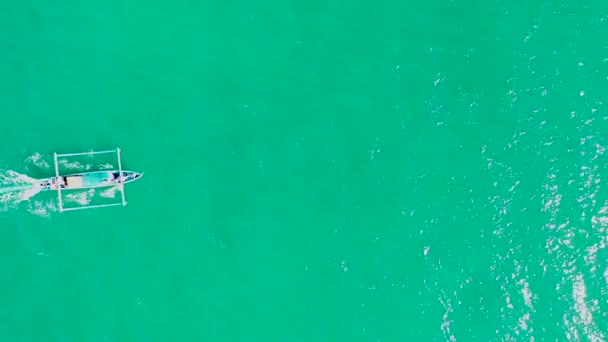 Aerial top down view of a traditional fiherman boat Jukung, a small indonesian boat navigating on paradise waters. Aerial view over a Asian fishing boat on the ocean - overhead, drone shot - Footage, Video