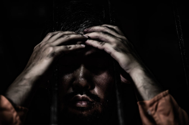 Portrait of man desperate to catch iron prison, prisoner concept - Foto, Bild