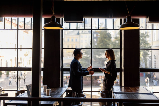 Ázsiai férfi és kaukázusi nő beszél a kávézóban - Fotó, kép