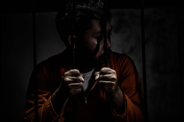 Portrait of man desperate to catch iron prison, prisoner concept - Foto, Imagen