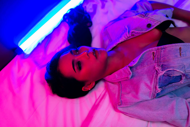 Portrait of beautiful sexy asian woman with neon light in the bedroom - Photo, Image
