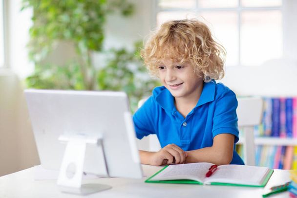 Online-Fernlernen. Schüler mit Computer unterhalten sich per Videokonferenz mit dem Lehrer und der Klassengruppe. Kind lernt von zu Hause aus. Hausaufgabenbetreuung während Quarantäne und Coronavirus-Ausbruch. - Foto, Bild