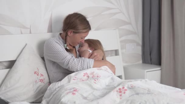 Mamá pone a su hija a la cama durante el día en su cama - Metraje, vídeo