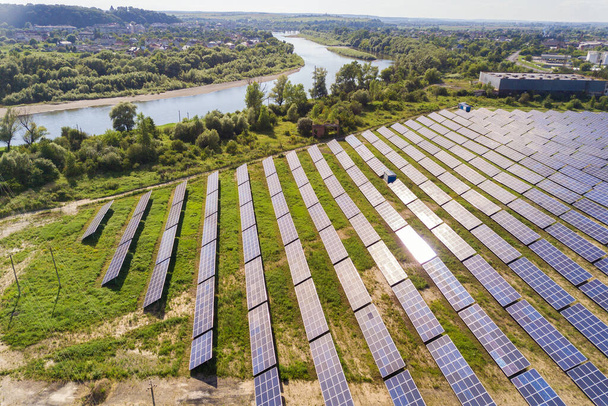 Aerial view of solar power plant on green field. Electric farm with panels for producing clean ecologic energy. - Photo, image