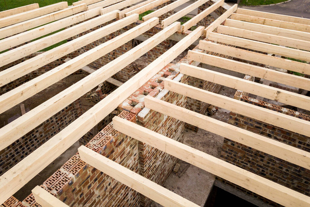 Gros plan d'une maison en brique avec cadre de plafond en bois en construction. - Photo, image