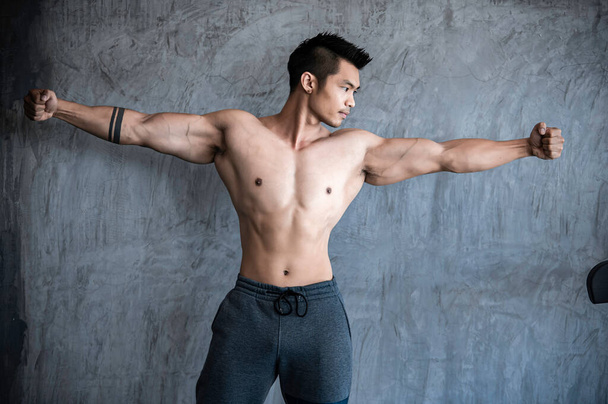 Portrét asijského muže s velkými svaly v tělocvičně, cvičení pro dobré zdraví - Fotografie, Obrázek