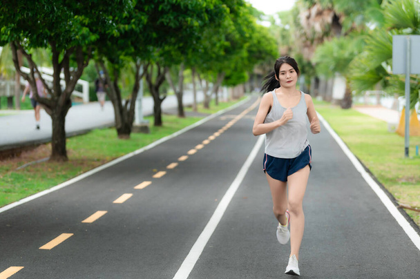 Aasialainen kaunis nainen juoksee puistossa, Thaimaa ihmiset, Juoksijat ajaa koulutusta kilpailuun, elämäntapa modernin naisen
 - Valokuva, kuva