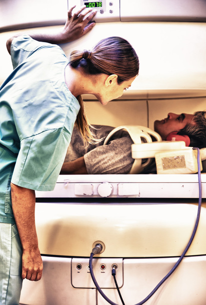 Médico femenino tranquilizador paciente masculino sometido a resonancia magnética
 - Foto, imagen