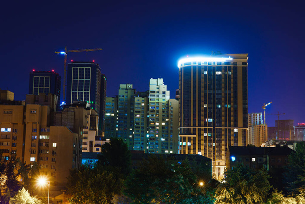 Näkymä eri korkeuksiin rakennuksiin yöllä. Suurkaupungin yömaisema Euroopassa - Valokuva, kuva