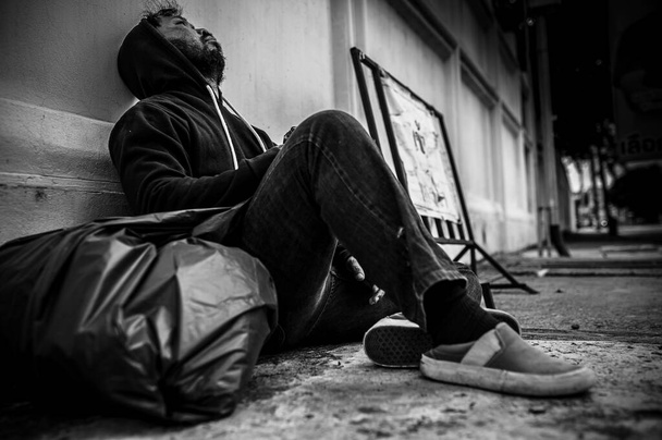 Aziatische dakloze man zitten aan de kant van de weg - Foto, afbeelding