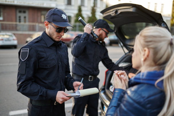 警察は女性を止め車をチェックする - 写真・画像