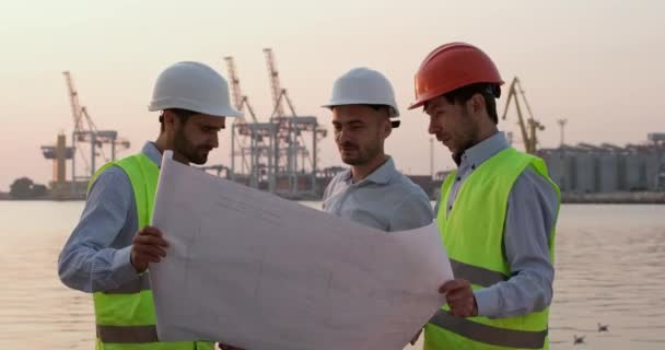 Инженеры обсуждают разграничение порта, стоящего против кранов - Кадры, видео