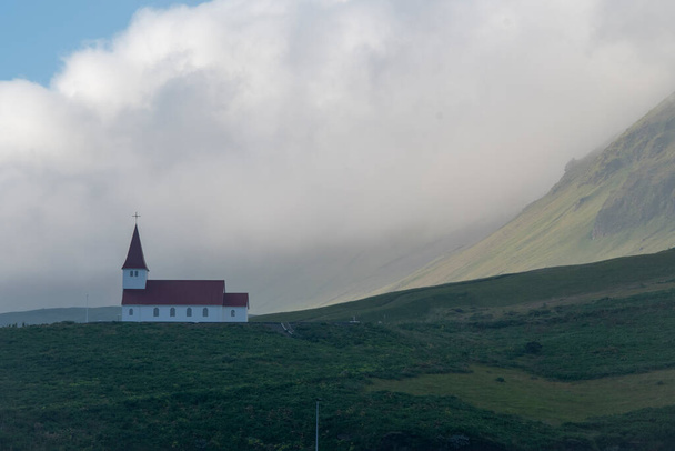 Landscape of Vik i Myrdal Church on a hill on summer day in Vik - Φωτογραφία, εικόνα