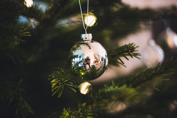Silberne Weihnachtskugel hängt im Weihnachtsbaum, Nahaufnahme - Foto, Bild