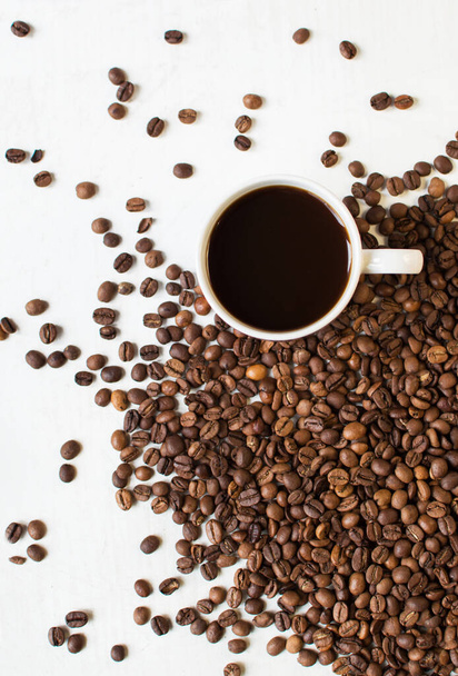 Tasse aromatischen Kaffees auf weißem Hintergrund und verstreuten Kaffeekörnern. Guten Morgen. Art von sveru. flach lag. Platz für Text. Kaffeezeit. - Foto, Bild