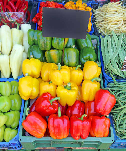 Colorful raw organic bell peppers in plastic crates sold on market - Photo, Image