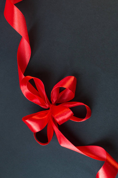 Black Friday - red ribbon with a bow on a dark background. Super sale, sales promotion and special offer. flat lay with place for text. Banner mockup, postcard. - Foto, immagini