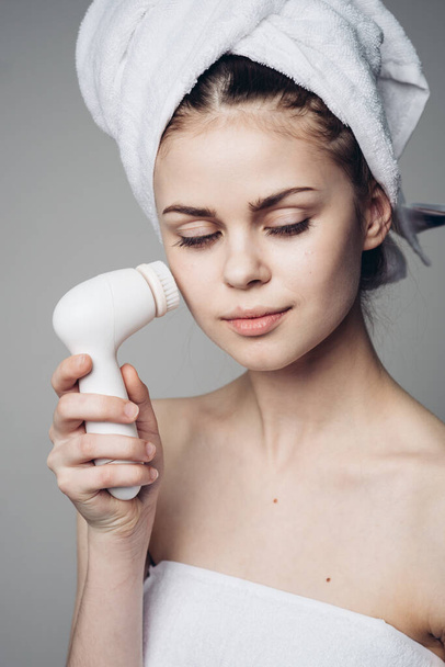 woman with towel on head facial massager skin care hygiene - Fotó, kép