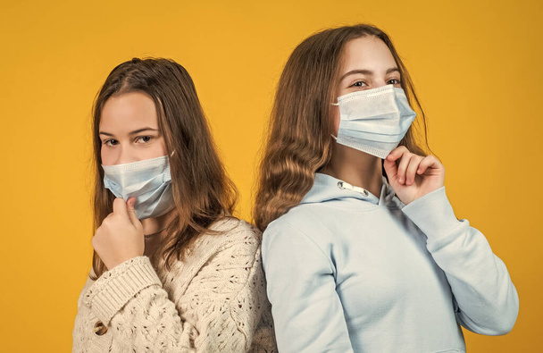 teen girls wear respirator mask while coronavirus pandemic quarantine, avoid contact - Fotografie, Obrázek