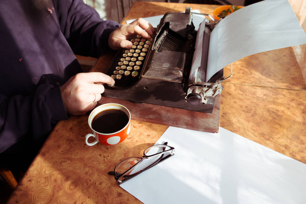 Mužský spisovatel píše svou knihu na starý psací stroj. Starý starožitný psací stroj.. - Fotografie, Obrázek