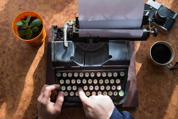 Male writer writing his book on an old antique typewriter. An old antique typewriter. - 写真・画像