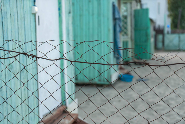 Edificios temporales de madera verde detrás de una cerca de alambre. Vivienda para refugiados - Foto, imagen