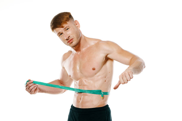 athletic man with measuring tape muscle workout - Foto, afbeelding