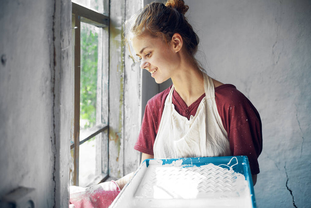 woman in apron painter repair painting window - Fotoğraf, Görsel