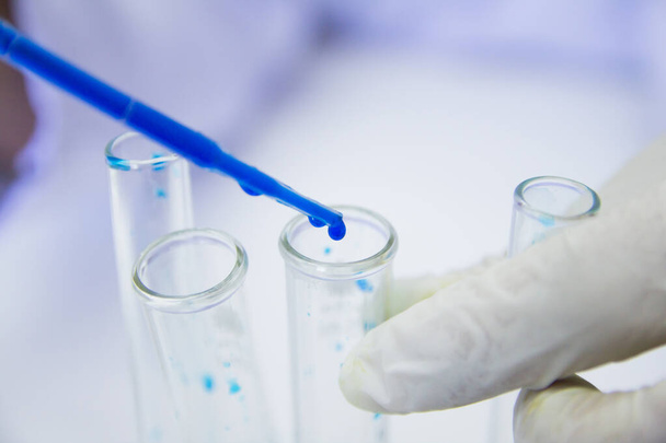 Fecha. Trabalhador médico em pesquisa em sala de laboratório realiza testes com líquido azul, Tratamento Experimental de Drogas - Foto, Imagem