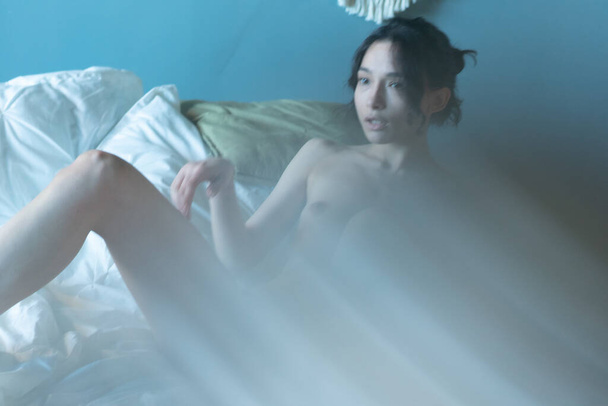 jovem bela mulher posando nua no estúdio, deitado na cama - Foto, Imagem