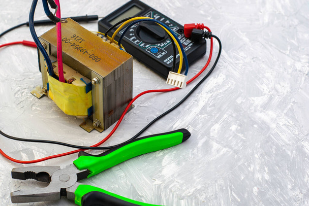 плоскогубці електричного трансформатора та ампервольтметр на поверхні столу. Високоякісна фотографія
 - Фото, зображення