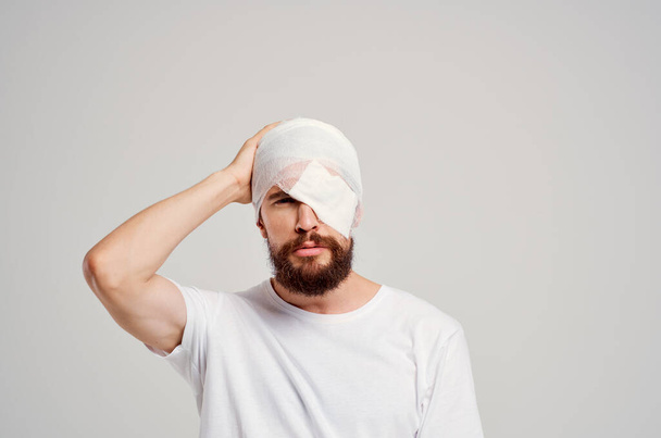 Sakallı, başı bandajlı ve gözü kanlı bir adam. - Fotoğraf, Görsel