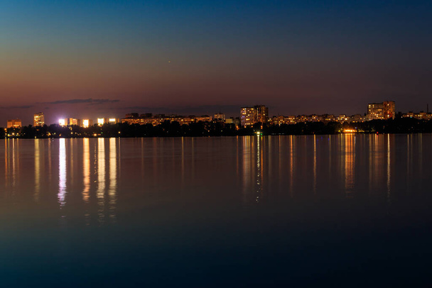 Night view of the Dnieper river and Dnipro city in Ukraine - Foto, afbeelding