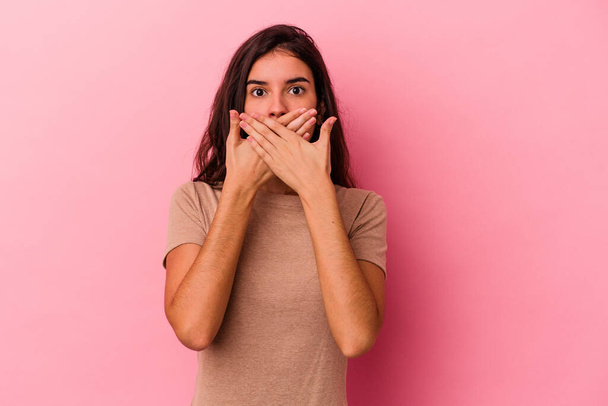 Junge kaukasische Frau isoliert auf rosa Hintergrund schockiert Mund mit Händen bedecken. - Foto, Bild