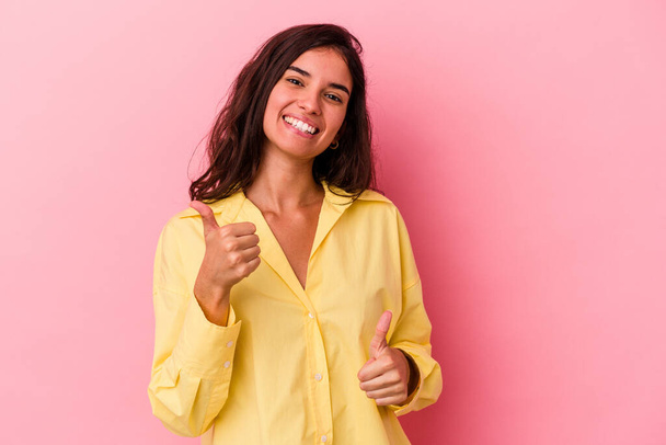 Jonge blanke vrouw geïsoleerd op roze achtergrond het verhogen van beide duimen omhoog, glimlachen en zelfverzekerd. - Foto, afbeelding