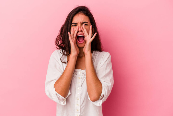 Young caucasian woman isolated on pink background shouting excited to front. - Foto, afbeelding