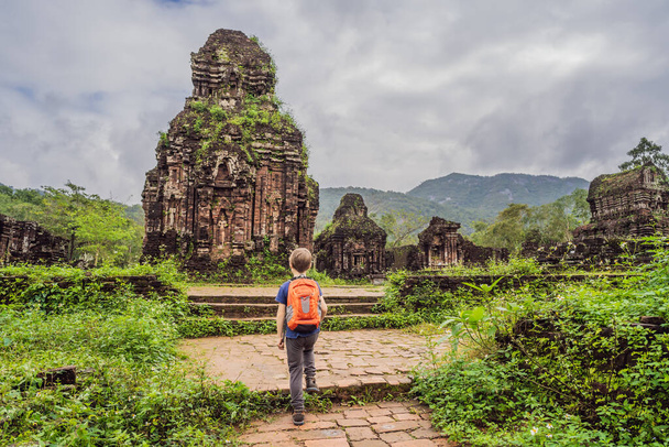 Boy tourist in Temple ruin of the My Son complex, Vietnam. Vietnam opens to tourists again after quarantine Coronovirus COVID 19 - 写真・画像