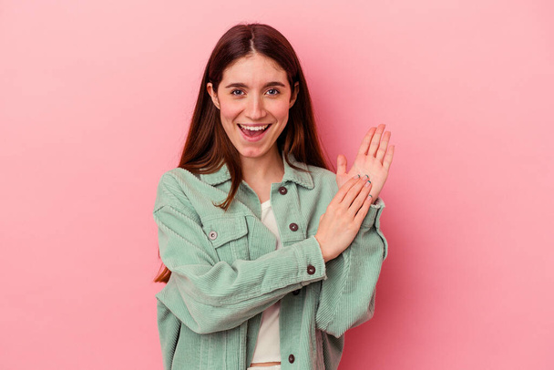 Young caucasian woman isolated on pink background feeling energetic and comfortable, rubbing hands confident. - Foto, imagen