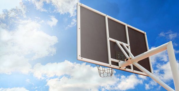 Баскетбольный рюкзак с корзиной из железных цепей, крупным планом на фоне голубого неба. Принято. Вид под низким углом - Фото, изображение