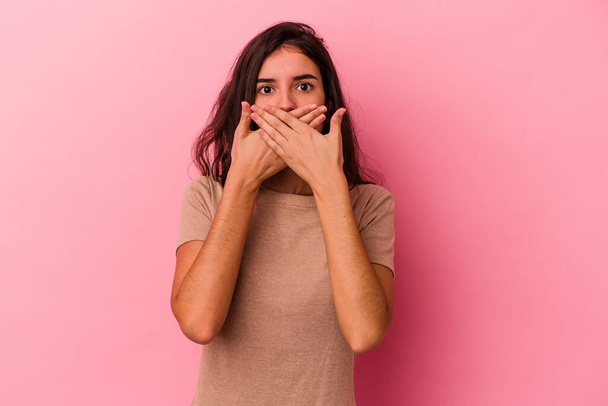 Giovane donna caucasica isolata su sfondo rosa che copre la bocca con le mani cercando preoccupato. - Foto, immagini