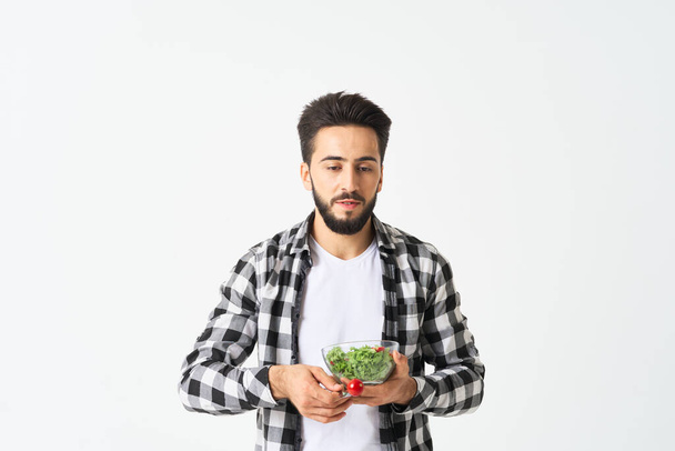 uomo allegro in piatto camicia a quadri con insalata cibo sano - Foto, immagini