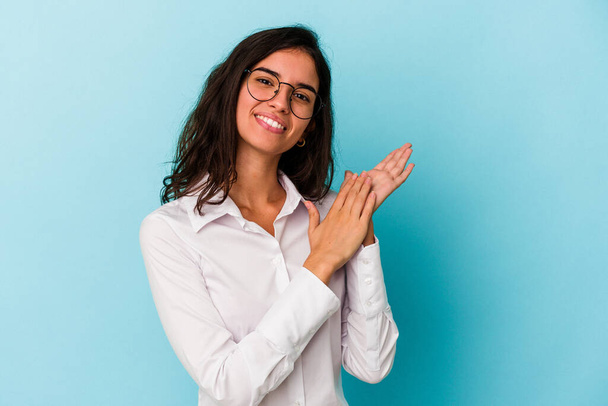 Young caucasian woman isolated on blue background feeling energetic and comfortable, rubbing hands confident. - Photo, Image