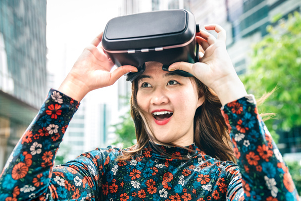 Młoda, zdumiona kobieta po doświadczeniu okularów VR - wirtualna rzeczywistość i założona koncepcja tech z dziewczyną bawiącą się maską gogli - Generacja z cyfrowych trendów na filtrze kontrastowym - Zdjęcie, obraz