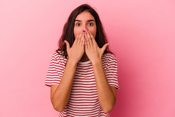 Young caucasian woman isolated on pink background shocked, covering mouth with hands, anxious to discover something new. - Fotografie, Obrázek