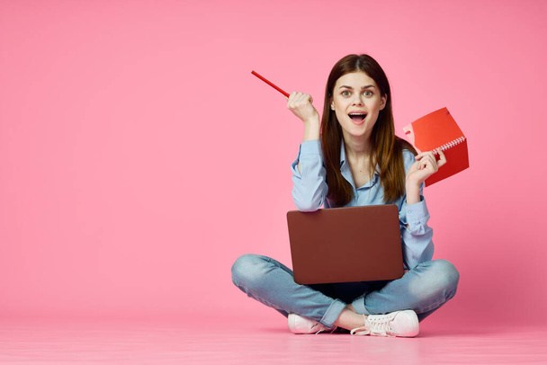 woman sitting on floor with laptop shopping entertainment pink background - Foto, immagini