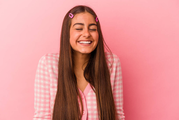 młoda kaukaska kobieta odizolowany na różowym tle śmieje się i zamyka oczy, czuje się zrelaksowany i szczęśliwy. - Zdjęcie, obraz