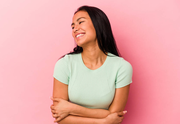Young Venezuelan woman isolated on pink background smiling confident with crossed arms. - Photo, Image