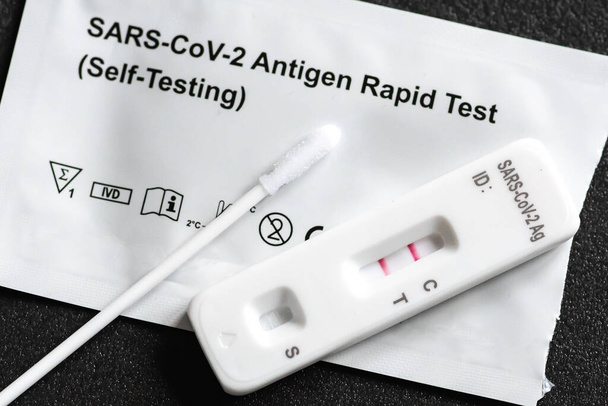 Pozitivní Covid-19 antigen test kit, jeden krok koronavirus antigen rychlý test, slinný tampon, 1 testovací box s představou plic, zblízka - Fotografie, Obrázek