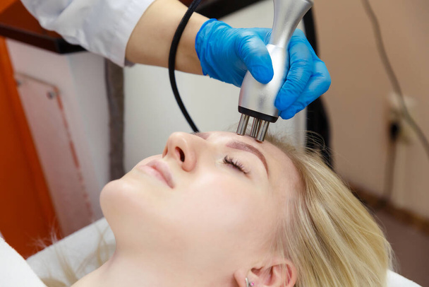 The process of correcting the face contour of a young woman using RF-lifting in a beauty salon. - Valokuva, kuva